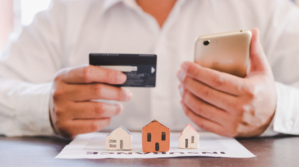 Businessman using credit card for buy home insurance.