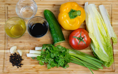 Fresh vegetables and spices on the wooden background.  