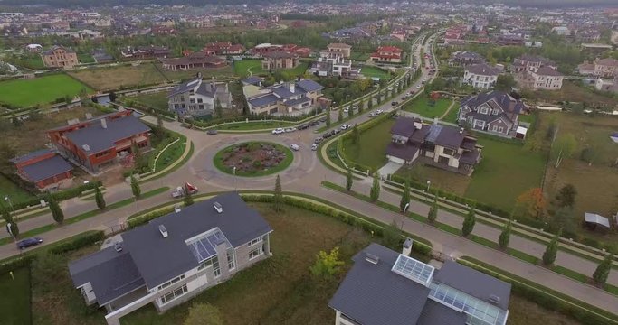 Aerial view over beautiful cottages. Small green village from above, top view of Houses in a neighborhood area. Countryside, real estate and private property concept.