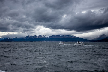 two boats sailing before landscape of Patagonian mountains, taken from the beagle channe. Ushuaia, patagonia