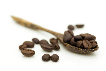 Naklejka premium Coffee beans in a wooden spoon on a white background. Image use for coffee production, energy drink in the morning.