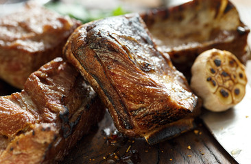 Grilled beef ribs wooden board close up