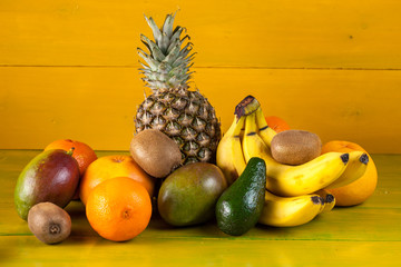 Tropical fruit on yellow wooden background, fresh food