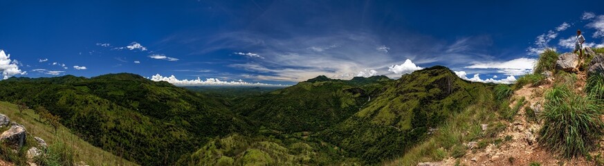 Fototapeta premium Panoramic view from Adam's peak small Ella. Woman standing at touristic viewpoint. Beautiful place of Sri lanka