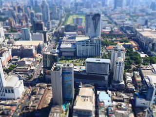 Fototapeta na wymiar Miniature Tilt shift lens effect of aerial view of midtown skyscrapers in Bangkok.