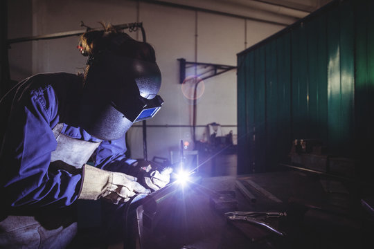 Female welder working on a piece of metal