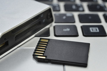 SD card and card reader on keyboard notebook background