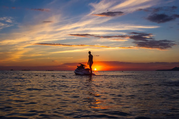 silhouette of a man on a jet ski in the sun
