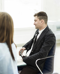 successful employee sitting behind a Desk in the office .