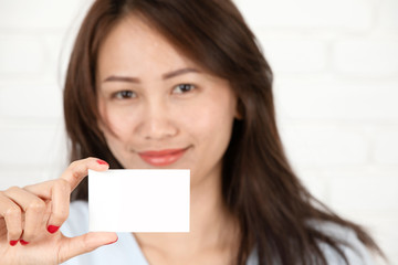 Asian woman smiling holding the card.