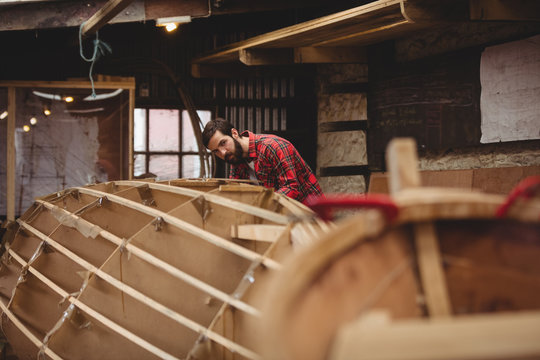 Man preparing wooden boat frame