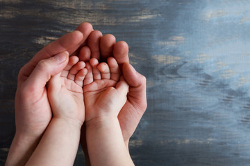 Two pairs of empty hands Adult and Children on a dark wooden background.