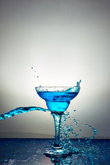 Glass with blue champagne or cocktail. Levitation