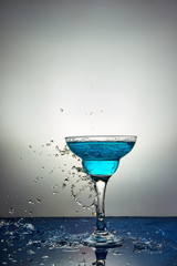 Glass with blue champagne or cocktail. Levitation