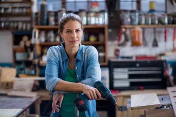 Female carpenter with drilling machine