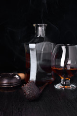 Glass of whiskey with smoking cigar.