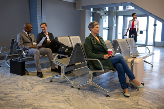 Woman sitting with luggage at waiting area