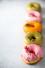 Sweet and colourful doughnuts on grey background. Fresh baked donuts. Copy space.