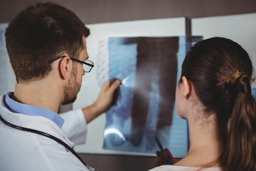 Physiotherapist explaining spine x-ray to female patient