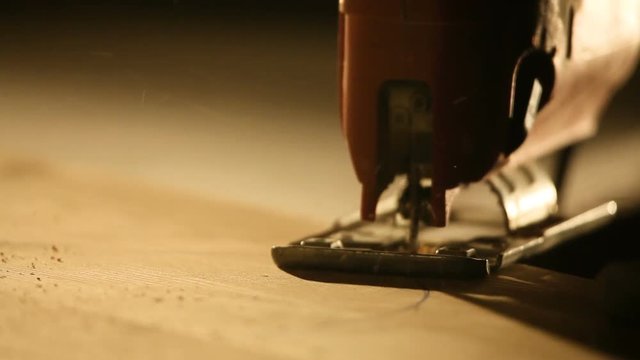 Man with electric jigsaw. Cutting board,close up shot
