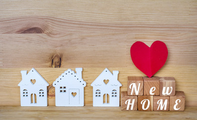 New Home  Concept with Small White Houses and Red Heart on a Wooden Background