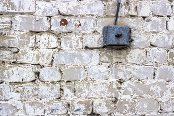 electric switch on an old white brick wall