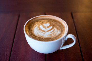 Hot Latte coffee cup heart shape on wooden table