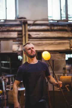 Glassblower shaping a molten glass