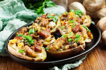 Baked potatoes in jacket stuffed with bacon, mushrooms and cheese. Dish served in baking dish..Baked potatoes stuffed with bacon, mushrooms and cheese