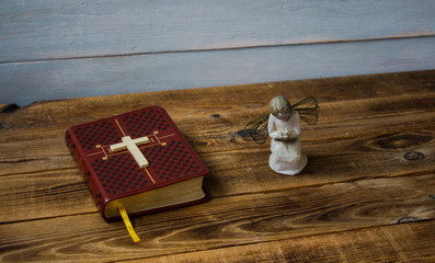 Naklejka premium angel bible and cross on wooden background