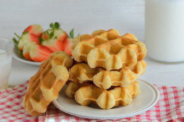 Fresh belgian waffles  served wirh strawberry and milk for breakfast. Delicious homemade dessert background.