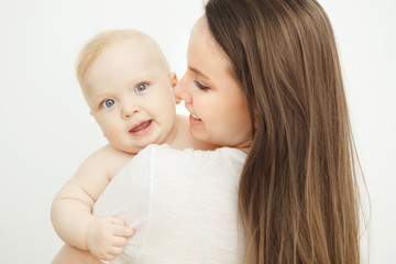 Mother looks at child with care love, baby on arms