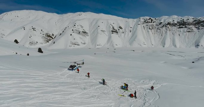 Skiers and snowboarders go to the Helicopter in the winter mountains