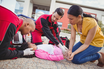 Paramedics examining injured girl