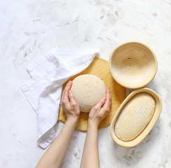 The woman's hands.  Dough for bread on leaven, yeast, in baskets for proofing dough.
