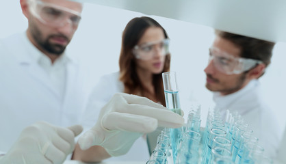 Fototapeta premium background image is a group of scientists studying the liquid in the glass tube.