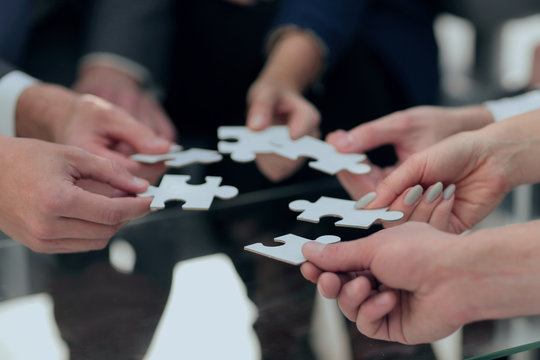 Business people holding jigsaw puzzle.