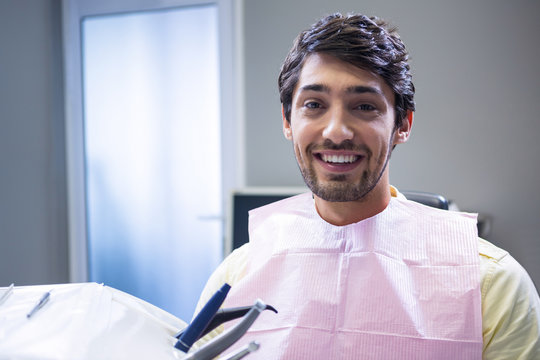 Smiling patient sitting on dentist's chair