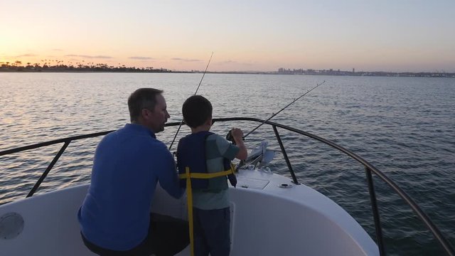 Father and son fishing off the front of their boat together