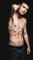 Obraz premium Portrait of glad young man with attractive body keeping head by hand. Happiness concept