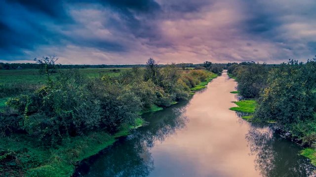 Panning cinamegraph of a lightning storm in a dramatic cloudscape over a dark river