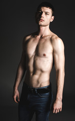 Fototapeta na wymiar Portrait of serene male stripped to waist looking at camera. He isolated on black background