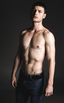 Portrait of serene male stripped to waist looking at camera. He isolated on black background