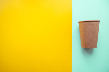 Paper cup on bright color background.
