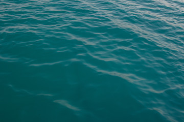 Surface of water with waves background texture, clear blue water in a red sea with a wave, dark blue sea wave close up, green water, glare of light on the water