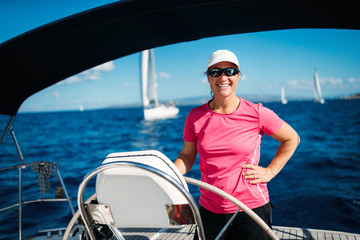 Happy strong woman sailing with her boat