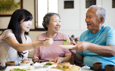 daughter and senior parent enjoy dinner in restaurant.