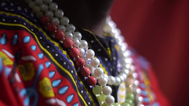 Shooting close-up of a black man in bright dashiki and colorful beads