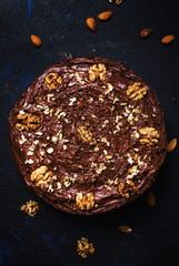 Homemade chocolate cake with nuts, black background, top view