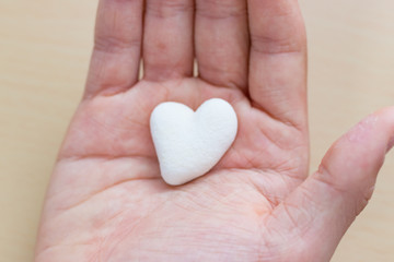 Fototapeta premium 手のひらに乗せたハート型のサンゴ石